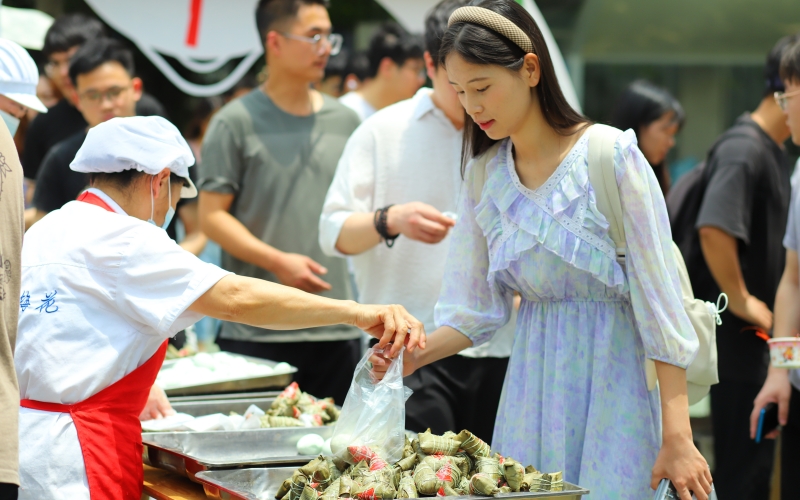 武汉轻工大学学生在领取粽子和鸭蛋。陈卓琳摄